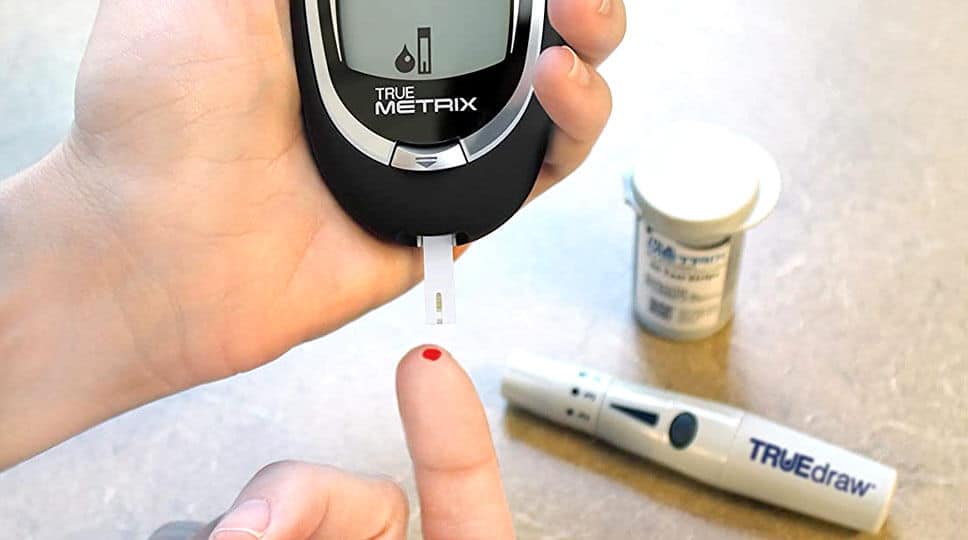 A man is testing his blood glucose with the TRUE METRIX® Meter Starter Kit, and Glucometer.